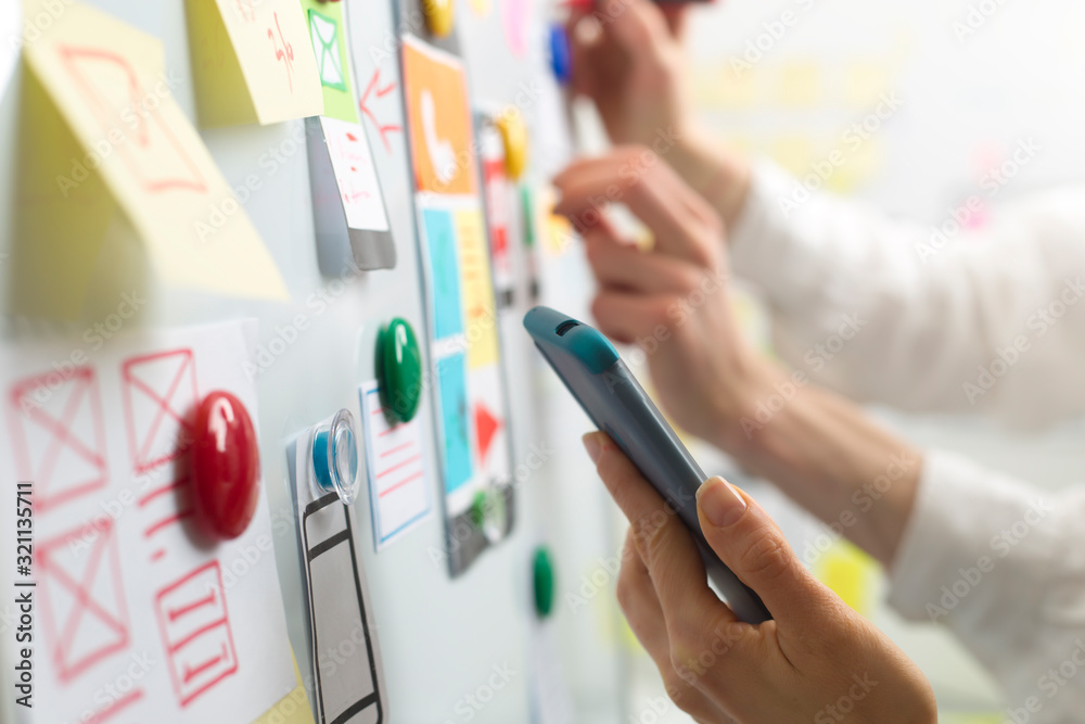 Poster ui website designers are developing a mobile phone application interface. user experience