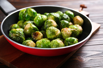 Roasted Brussels sprouts in pan on wooden table