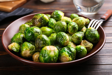 Roasted Brussels sprouts in plate on wooden table