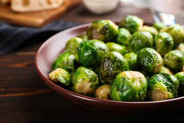 Roasted Brussels sprouts in plate on wooden table