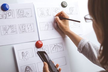 Woman draws a storyboard for an animated film on a white board.  - 321135778