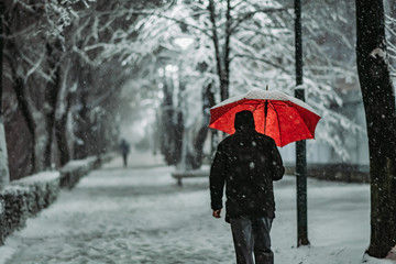 Man walking with umbrella on snow 