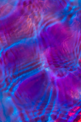 Fototapeta na wymiar Purple iridescent water ripple conceptual photo