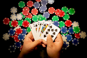 Manos con naipes y fichas de poker