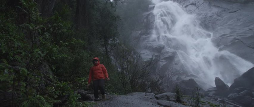 Woman hiking below waterfall, Squamish, British Columbia, Canada