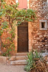 Fototapeta na wymiar Roussillon, France, 24 aout 2012 : Porte et facade d'une maison dans le petit village de Roussillon