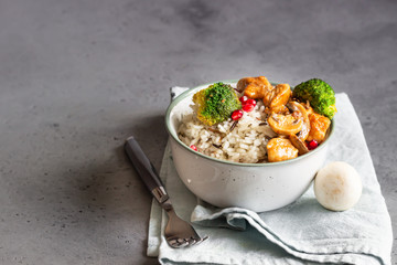 Curry chicken with rice, mushroom and broccoli decorated with pomegranate seeds. Healthy food. Asian cuisine.