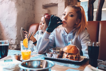 Two teenage girls sitting in cafe together
