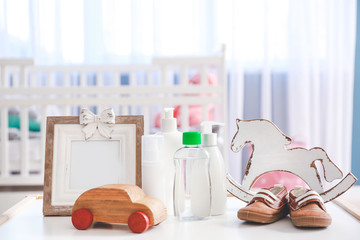 Baby toys with cosmetics on table in room