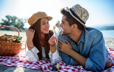 Picnic. Young couple having fun on the beach. Lifestyle, love, dating, vacation concept