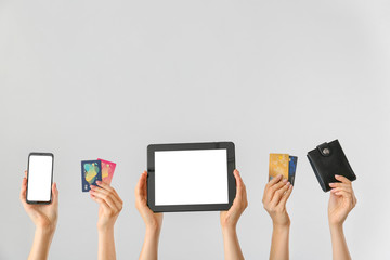 Female hands with mobile phone, credit cards, wallet and tablet computer on light background....
