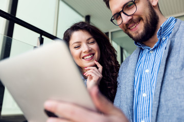 Businesswoman and businessman working on tablet device