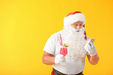 Fototapeta na wymiar Santa Claus with cocktail and mobile phone on color background. Concept of vacation