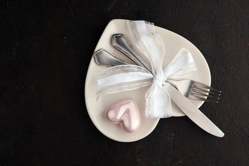 White heart on white dish. Meal on Valentines Day with fork