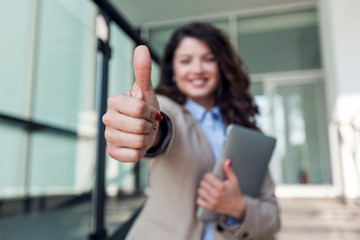 Beautiful smiling business woman showing thumbs up sign 