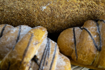 Different kinds of fresh bread with grain on black rustic background.