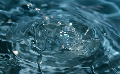 Conceptual image for water purity. Blue water splash​ed for background. Drops and waves in a...