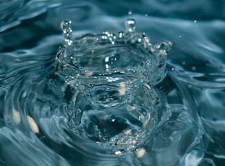 Fototapeta na wymiar Conceptual image for water purity. Blue water splash​ed for background. Drops and waves in a glass.