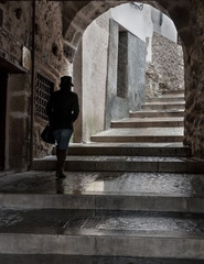 Fototapeta na wymiar Mujer paseando por escalera en un pasadizo de Cuenca