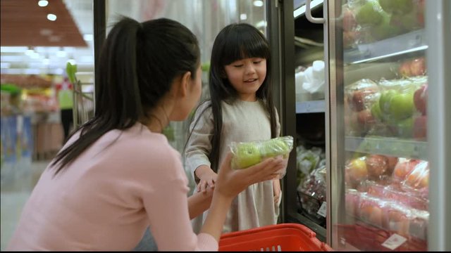 Shopping concepts. The daughter is buying fruit for her mother in the mall. 4k Resolution.
