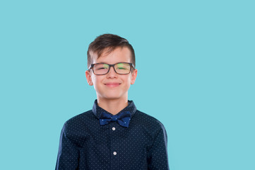Stylish boy in shirt and glasses with big smile. Ok. School. Preschool. Fashion. Studio portrait over blue background