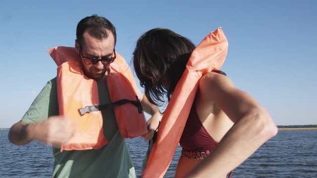 MS, Lockdown of a couple on a boat helping each other put on life jackets