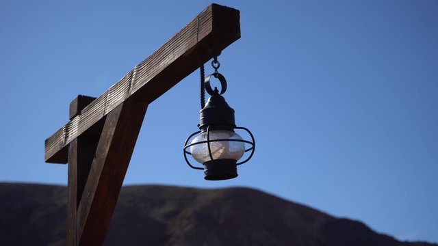 Old lamp hanging on woode pole