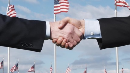 SLO MO, CU, Lockdown of two men shaking hands in front of American flags, Washington DC, USA