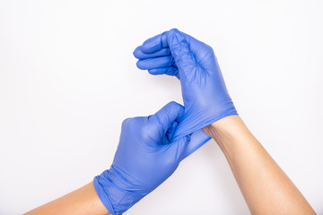 Doctor or nurse putting on blue nitrile surgical gloves, professional medical safety and hygiene...
