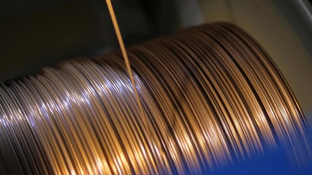 Winding a copper cable on a rotating coil. Production of electric cable.