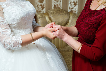 bride and mother holding hands on the wedding day - Powered by Adobe