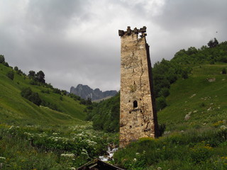 Mountain landscape of Svaneti on bright summer sunny day. Mountain lake, hills covered green grass on snowy rocky mountains background. Caucasus peaks in Georgia. Amazing view on wild georgian nature