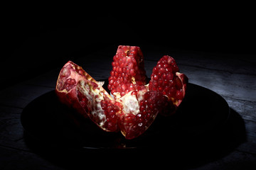 garnet on a black plate on a black background in a low key