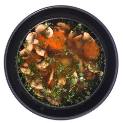 Mushroom soup in a black plate. White background.