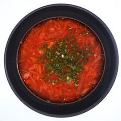 Borsch in a black plate on a hot background.