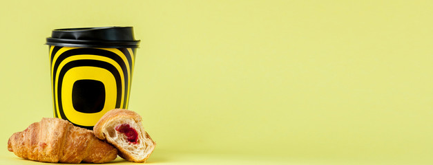 Paper cup of coffee and croissants on a yellow background, Copy space