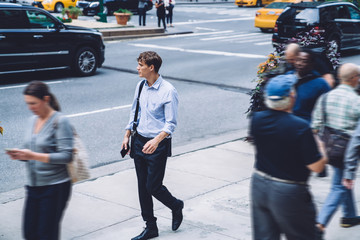 Confident businessman holding bag walking on street