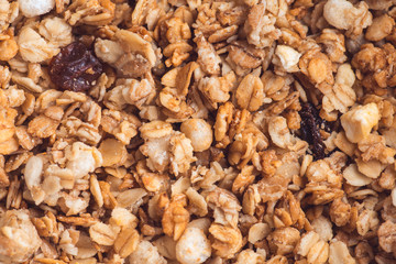 Useful and tasty muesli with nuts, rasins and flakes. Selective focus macro shot with very shallow depth of field. Healthy and vegetarian lifestyle