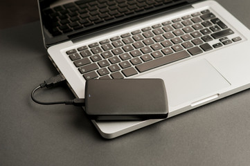 external hard drive black on laptop, on office table, black. 