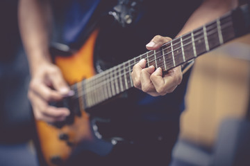 Fototapeta na wymiar Close up hand of Guitarist plays guitar solo