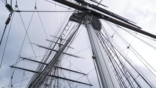 Close-up of the rigging and mast of Cutty Sark ship against the blue cloudy sky. Action. Greenwich, London