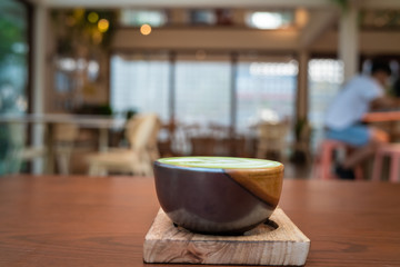 Hot matcha green tea l;atte art on wooden table