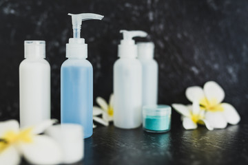 lotions and moisturizer bottles on black marble shot at shallow depth of field