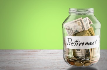 Coins in glass money jar on desk