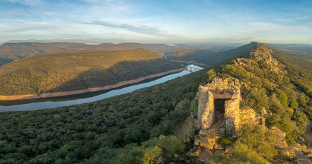 Obraz premium Amazing views during sunset of Extremadura countryfields, its woods and Tajo river from the awesome Monfragûe Castle a great defensive position on a hill with an old Muslim fort in the top of the hill