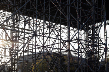 The structure formed by joining light metal construction pipes. Sun rays during sunset.