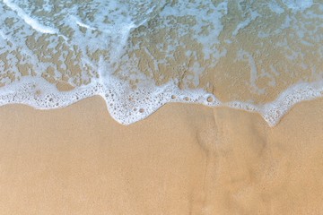 Fototapeta na wymiar White wave on brown sand beach, nature background, outdoor day light