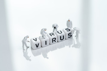 Miniature people doctors with protective suit inspecting cube block combine the word Virus using as quarantine or prevention of fast spreading coronavirus, COV flu outbreak concept