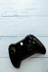 Black joystick on a white wooden floor. Closer.