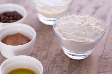 chocolate cookie ingredients on wooden table. Emphasis on the flour.